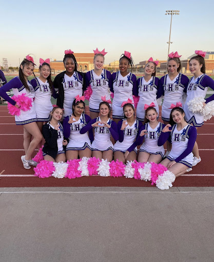 IHS cheerleading posing on the field before a football game. 
