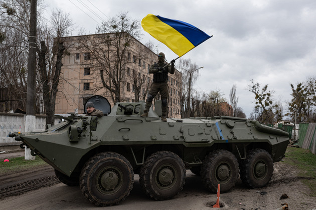 Ukrainian soldier waves flag of Ukraine standing atop a tank on April 8, 2022 in Hostomel, Ukraine. (Getty)