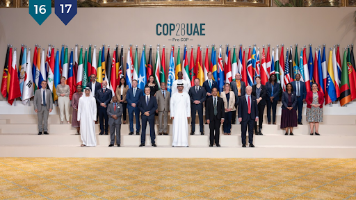 Delegates pictured at the conference, with Dr. Sultan Al Jaber, (front row, center) the COP 28 president. COP 28 has a record number of delegates, making it one of the largest COPs in United Nations history. The U.N. has also published a list of speakers at the conference (DA News). 