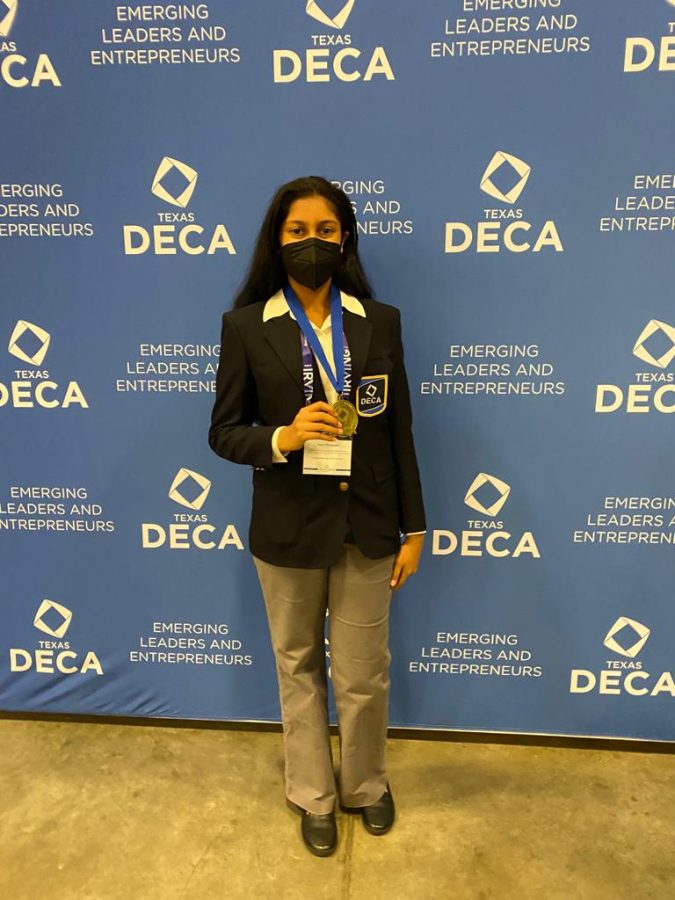 Tanvi Muppala holds an award at a district DECA competition.