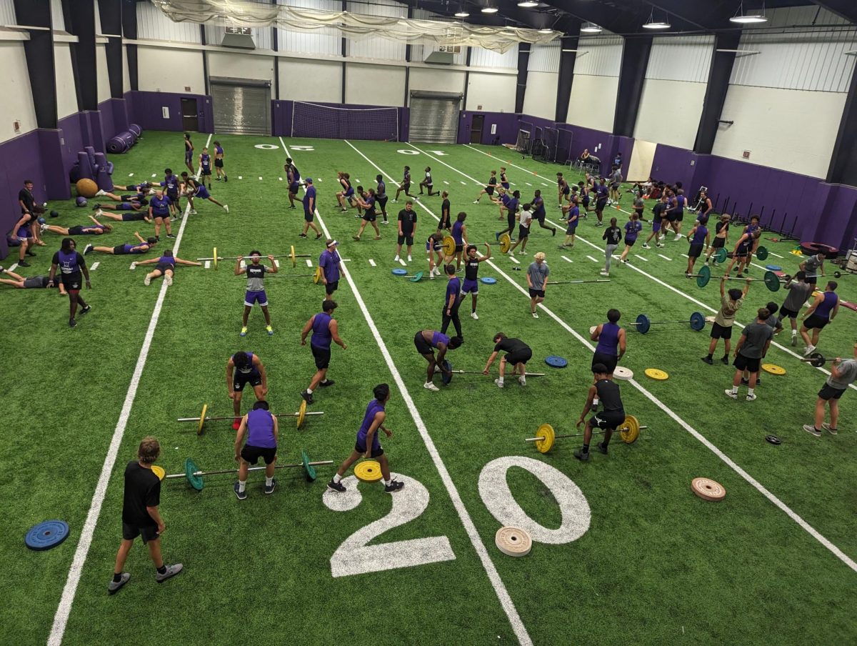 The athletes work out on the turf, where they are split into different groups to maximize connection between different sports (Zachary Stokes) 
