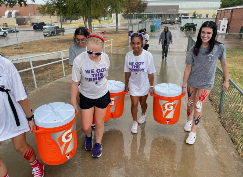 Team members carrying coolers of Gatorade to distribute to the athletes at a football game on Sept. 15, in the Kuykendall Stadium (Kiara Uppal) 
